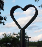 A hand forged heart decorates the top of the lamp.